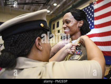 Manama, Bahrain. 13th Sep, 2018. MANAMA, Bahrain (Sept. 13, 2018) Chief Logistics Specialist Suzette Loy, left, pins anchors onto Chief Logistics Specialist Josianne Thompson during a chief petty officer pinning ceremony at Naval Support Activity Bahrain. Sixty-eight Sailors from U.S. Naval Forces Central Command, Naval Support Activity Bahrain, and commands located throughout the U.S. 5th Fleet area of responsibility received their anchors. (U.S. Navy Photo by Mass Communication Specialist 2nd Class Samantha P. Montenegro/Released) 180913-N-RM440-1229 US Navy via globallookpress.com (C Stock Photo