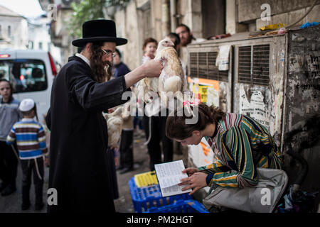 17 September 2018, ---, Jerusalem: An ultra-Orthodox Jewish man swings a chicken over the head of a young woman as part of the Jewish ritual 'Kaparot', that performed before Yom Kippur, the Day of Atonement, in Jerusalem, 17 September 2018. The 'Kaparot' ritual is believed to transfers sins from the past year into chickens, and is performed before Yom Kippur, the holiest day in the Jewish calendar. Photo: Ilia Yefimovich/dpa Credit: dpa picture alliance/Alamy Live News Stock Photo