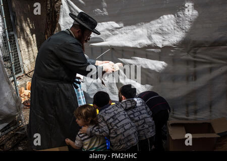 17 September 2018, ---, Jerusalem: An ultra-Orthodox Jewish man swings a chicken over the heads of his children as part of the Jewish ritual 'Kaparot', that performed before Yom Kippur, the Day of Atonement, in Jerusalem, 17 September 2018. The 'Kaparot' ritual is believed to transfers sins from the past year into chickens, and is performed before Yom Kippur, the holiest day in the Jewish calendar. Photo: Ilia Yefimovich/dpa Credit: dpa picture alliance/Alamy Live News Stock Photo