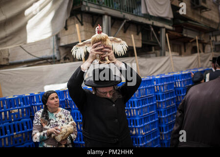 17 September 2018, ---, Jerusalem: An ultra-Orthodox Jewish man swings a chicken over his head as part of the Jewish ritual 'Kaparot', that performed before Yom Kippur, the Day of Atonement, in Jerusalem, 17 September 2018. The 'Kaparot' ritual is believed to transfers sins from the past year into chickens, and is performed before Yom Kippur, the holiest day in the Jewish calendar. Photo: Ilia Yefimovich/dpa Credit: dpa picture alliance/Alamy Live News Stock Photo