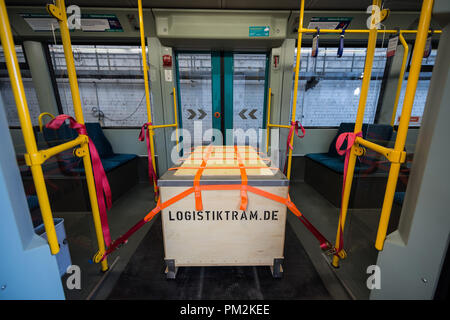 17 September 2018, Hessen, Frankfurt Main: A box used to transport goods with the inscription 'Logistiktram.de' secured with tension belts in a tram at the VGF depot Gutleut. The pilot project 'Logistiktram' is to serve the climate-friendly transport of goods. Photo: Silas Stein/dpa Stock Photo