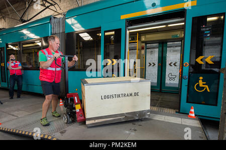 17 September 2018, Hessen, Frankfurt Main: A box used to transport goods with the inscription 'Logistiktram.de' pushed into a tram with a forklift truck at the VGF depot Gutleut. The pilot project 'Logistiktram' is to serve the climate-friendly transport of goods. Photo: Silas Stein/dpa Stock Photo