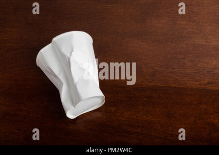 Crumbled White paper coffee cup on table. Stock Photo