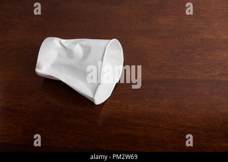 Crumbled White paper coffee cup on table. Stock Photo