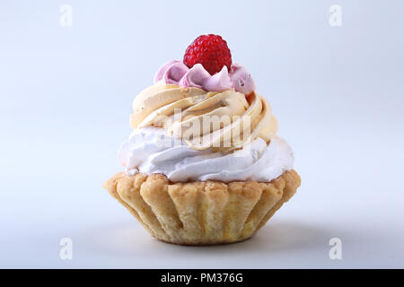 Tasty Homemade cupcake, muffin with cream and raspberry. Close up view delicious sweet dessert isolated on white. Stock Photo
