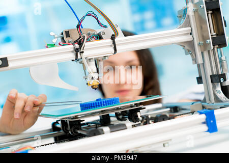female student or laboratory assistant in the automation laboratory is debugging the work of the 3d printer. 3d printer is a device for modeling objec Stock Photo
