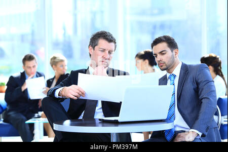 business partners discussing a new project, sitting in the lobby of the office. Stock Photo