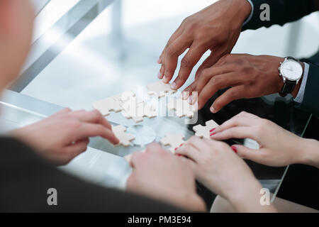 close up. business team assembling puzzle pieces. Stock Photo