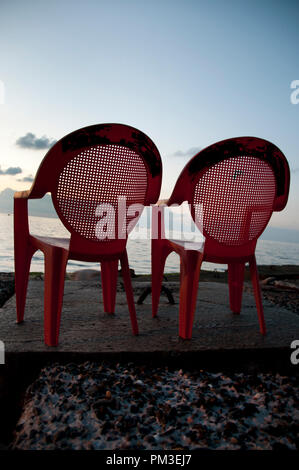 Egypt, Alexandria, 2014. Two red plastic chairs with a view of the Mediterranean sea. Stock Photo