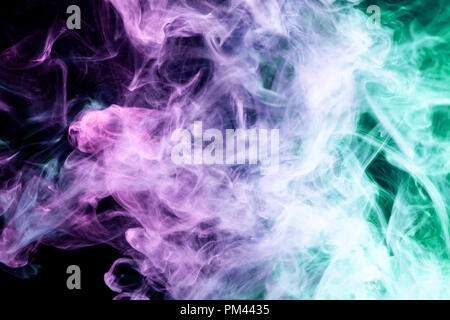 Thick colorful smoke of green, pink and  blue on a black isolated background. Background from the smoke of vape Stock Photo