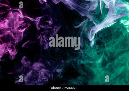 Colorful pink, blue  and green smoke  on a black isolated background. Background from the smoke of vape Stock Photo