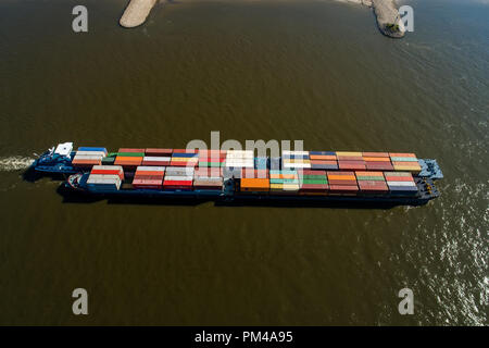 Rhine - Netherlands, July 14, 2018: aerial view of a merchant ship with a container crossing the river Rhine in a region of the Netherlands Stock Photo