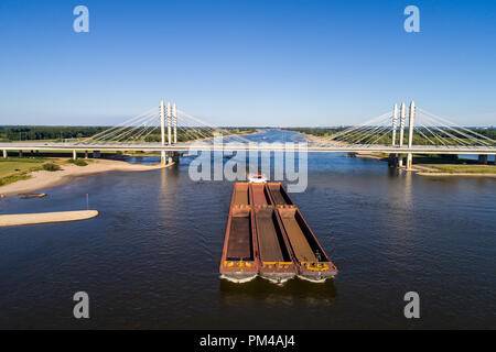 Aerial view of the ship crossing under a bridge on the river Rhine in an area of the Netherlands Stock Photo