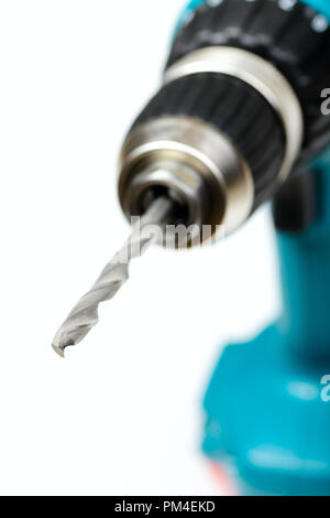 Cordless drill with twist drill bit on white background shallow focus Stock Photo