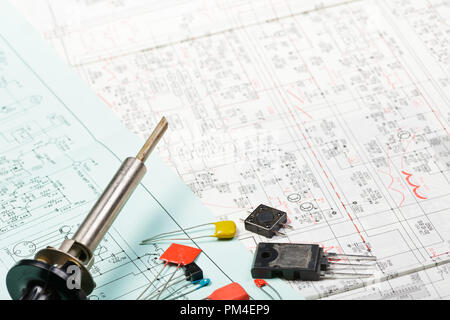 Soldering iron with electronics components on a scheme Stock Photo