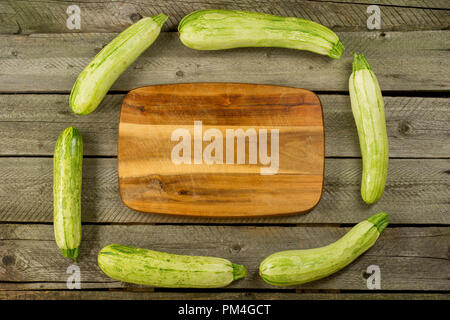 Light green fresh zucchini stacked, farm fresh produce, summer vegetables on rustic background. Top view Stock Photo