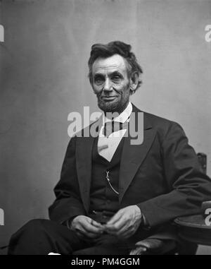 Abraham Lincoln, three-quarter length portrait, seated and holding his spectacles and a pencil. February 5, 1865.    File Reference # 1003 012THA Stock Photo