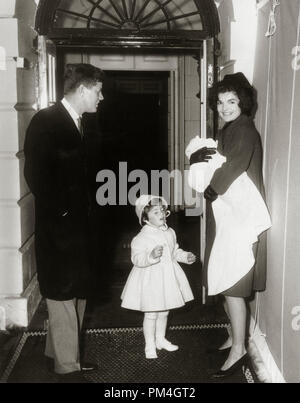 President John F. Kennedy with his wife, First Lady Jacqueline Bouvier Kennedy, and their daughter, Caroline, in front of a doorway at the White House, Washington, D.C.  Jacqueline Kennedy holds John Kennedy Jr. 1961.  (Photo courtesy of JFK Library)   File Reference # 1003 103THA Stock Photo