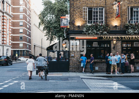London, UK - July 26, 2018: People and cars in front of Mabel's Tavern pub, a popular Shepherd Neame pub close to Euston and King's Cross, London, UK. Stock Photo