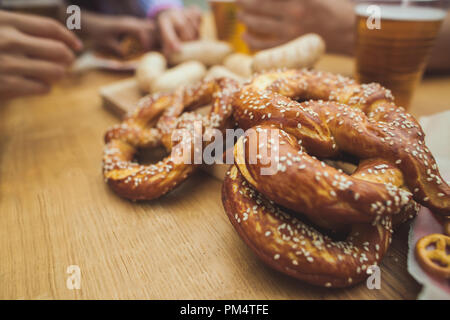 Boiled white sausages, served with beer and pretzels. Perfect for Octoberfest. Natural wooden background. Front view. Stock Photo