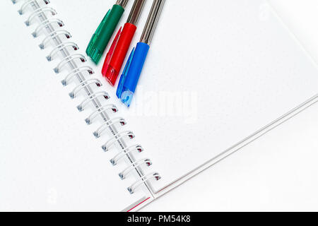pens red, blue, green on a blank white background notebooks Stock Photo