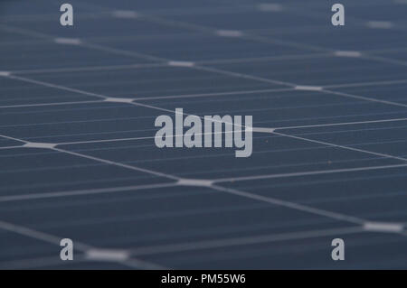Low angle photo of the surface of a solar panel that produces electricity directly from the sunlight. Stock Photo