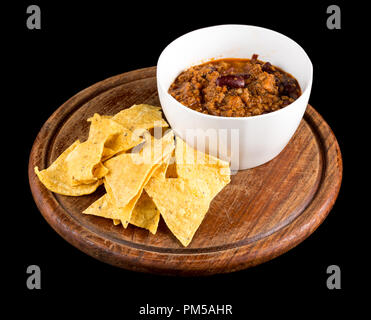 Tasty beef Chilli con carne served with Nachos isolated on black background. Studio Shot Stock Photo