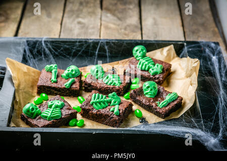 Halloween style party sweet - brownie with green skeleton and bones Stock Photo