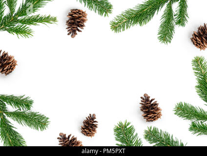 Merry Christmas layout composition, top view with fir tree branches and pine cones on a white background. Stock Photo