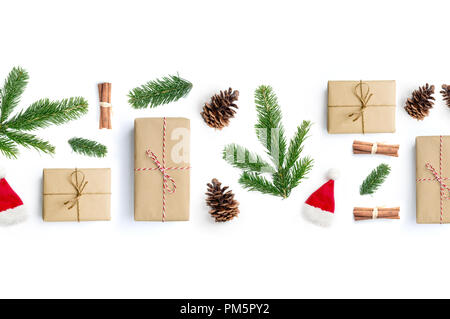 Happy Christmas layout composition, top view with xmas presents, cinnamon sticks, fir tree branches and pine cones on a white background. Stock Photo
