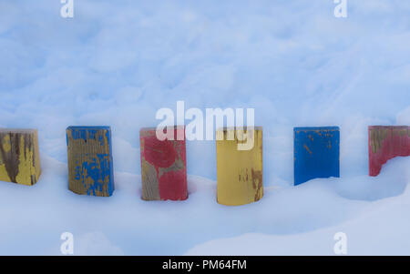 Textured Colorful Painted Blue, Red, Yellow Wooden Picket Fence Planks In Deep Snow, Colorful Rustic Style Background For Vintage Winter Season Wallpa Stock Photo