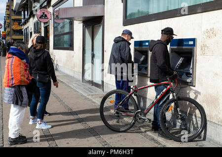 COPENHAGEN, DENMARK - SEPTEMBER 08, 2018:  People using a Danske Bank ATM in Copenhagen. Danske Bank is the largest bank in Denmark. According to a Wall Street Journal article on September 07, 2018, the bank is currently investigating to which extend it has been used to launder money from companies related to Russia and is examining transactions to a value of $150 billion that flowed through its small branch in Estonia. (Photo by Ole Jensen/Alamy) Stock Photo