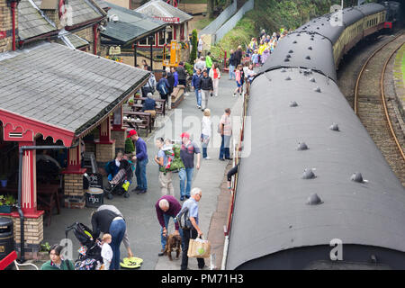 Busy train station platform at Haverthwaite preserved heritage railway in the Lake District as passengers disembark from the newly arrived train. Stock Photo