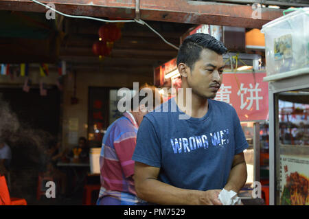 Kuala Lumpur, Malaysia - 10 September, 2017: Chinese street chef cooks traditional spicy flat noodles soup in the streets of Kuala Lumpur, Malaysia Stock Photo