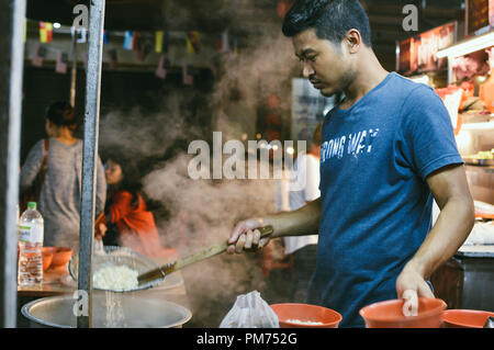 Kuala Lumpur, Malaysia - 10 September, 2017: Chinese street chef cooks traditional spicy flat noodles soup in the streets of Kuala Lumpur, Malaysia Stock Photo