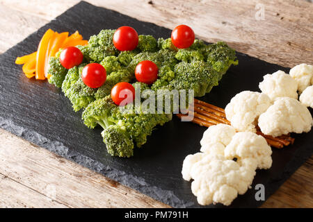 Christmas tree of broccoli, cauliflower, tomato, pepper closeup on table. Vegetarian menu. horizontal Stock Photo