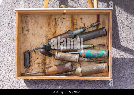 box of old or antique grease guns Stock Photo