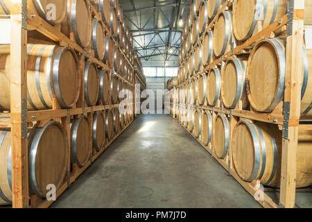 Wine barrels stacked in the old cellar of the winery Stock Photo