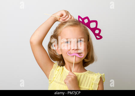 girl holding paper party sticks on a solid background Stock Photo