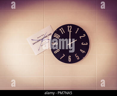 Big black clock on white wall. Time change. DST. Survey of the European Union on time change. English banner. Stock Photo
