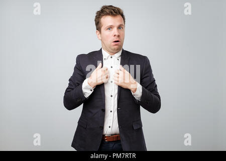 Are you accusing me, it was not my fault. Confused attractive man in suit shrugging and making clueless expression, being questioned and uninvolved Stock Photo