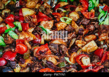 Minced meat stewed with paprika, tomatoes, onion, red bean and garlic in a clay bowl. Top view. Stock Photo