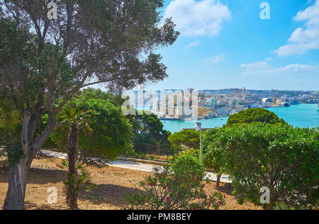 The juicy greenery of Herbert Ganado Gardens with a view on medieval Senglea (L-Isla) fortified city across the Grand Harbour of Valletta, Malta. Stock Photo