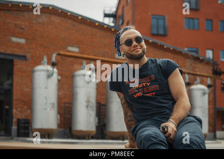 Portrait of young vaping man with dreadlocks. Vapor concept. Vaping e-Cigarette Stock Photo