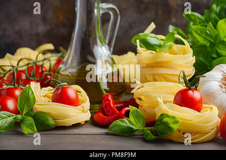 Pasta, vegetables, herbs and spices for Italian food on the wooden background, selective focus. Stock Photo