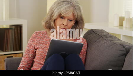 Beautiful mature woman tablet reading Stock Photo