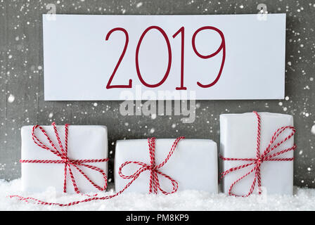 Three Christmas Gifts Or Presents On Snow. Cement Wall As Background With Snowflakes. Modern And Urban Style. Card For Birthday Or Seasons Greetings.  Stock Photo