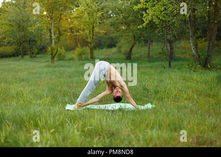 Young man doing yoga in the park Stock Photo