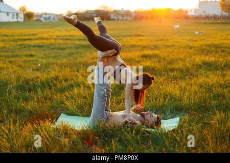 Young couple doing yoga at sunset. Lifestyle Healthy Stock Photo