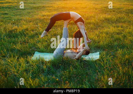Young couple practicing yoga on a beautiful sunset. Healthy lifestyle Stock Photo